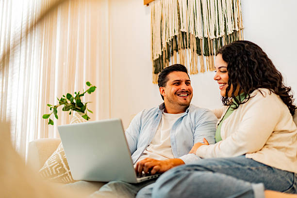 istock Couple talking and using laptop at home 2226557890
