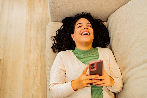 istock Happy young woman using mobile phone at home 2226558970