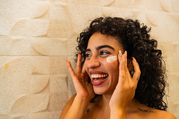 istock Happy young woman applying moisturizer 2226560311