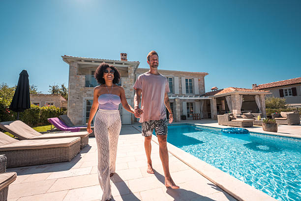 istock Mixed Race Couple Holding Hands by the Pool 2226566933