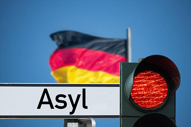 istock Flag of Germany, red light and sign asylum 2226570387