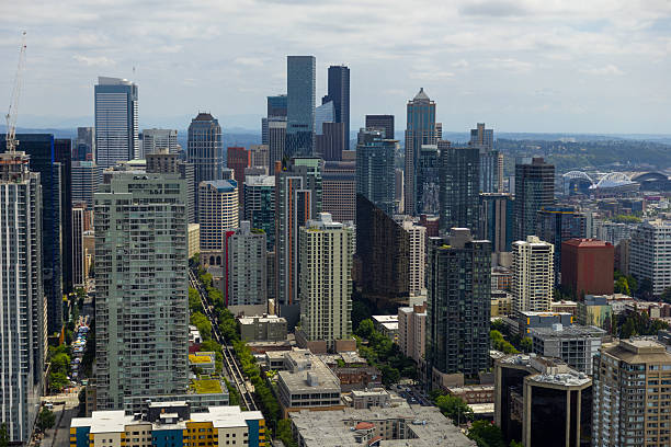 An aerial view looking at downtown Seattle from atop the Space Needle on a summer day that is partly cloudy