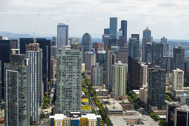 An aerial view looking at downtown Seattle from atop the Space Needle on a summer day that is partly cloudy