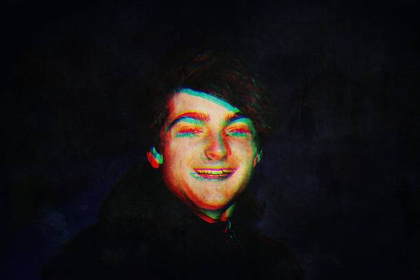 A multiple exposure image of a happy smiling teenage boy against a black background. Futuristic concept.