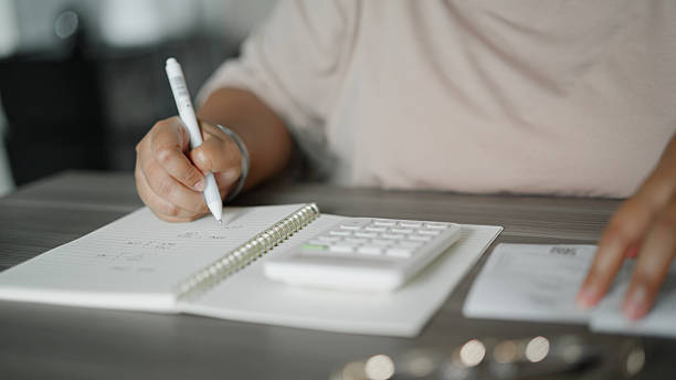 istock Asian woman calculating expenses at home 2226587421