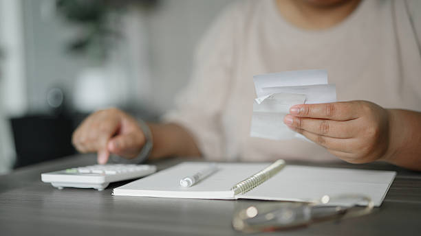 istock Asian woman calculating expenses at home 2226587449