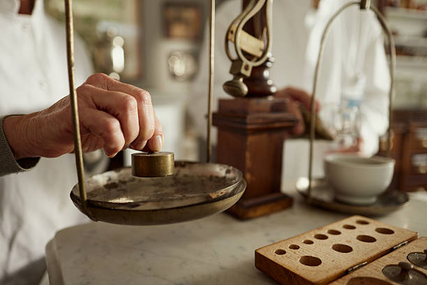 Close up of unrecognizable scientists measuring on a vintage weight scale in laboratory.