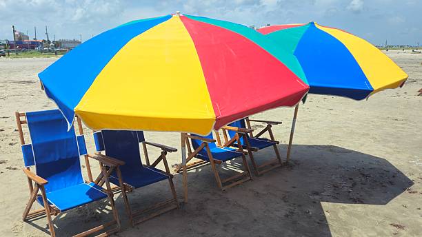 Colorful Beach Umbrellas and Beach Chairs on a beach with no people.