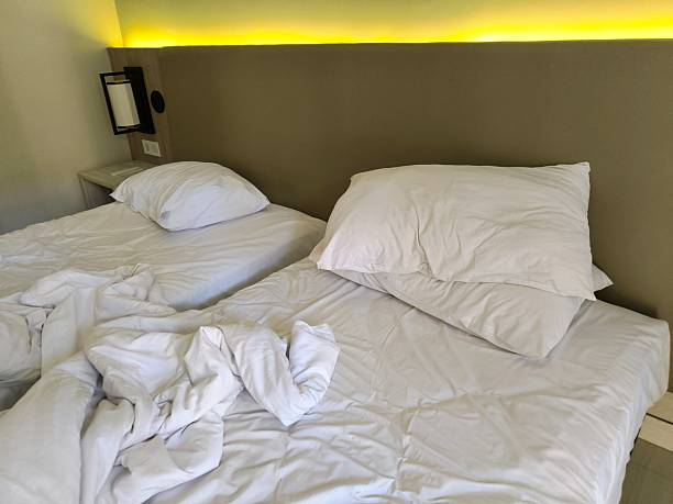 istock Crisp white hotel bed, slightly wrinkled after a restful night’s sleep 2226592742