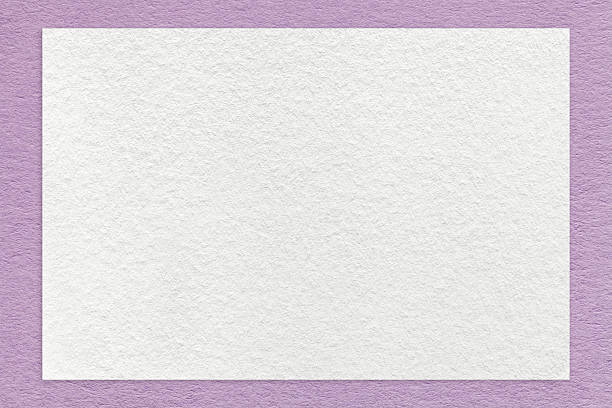 Texture of craft white color paper background with lilac border, macro. Structure of vintage dense kraft purple cardboard with empty frame. Backdrop with copy space.
