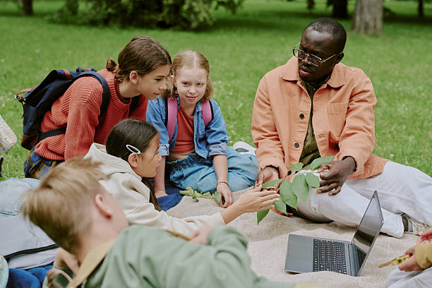 istock School Teacher Guiding Children Studying Nature Outdoors in Park 2226595491
