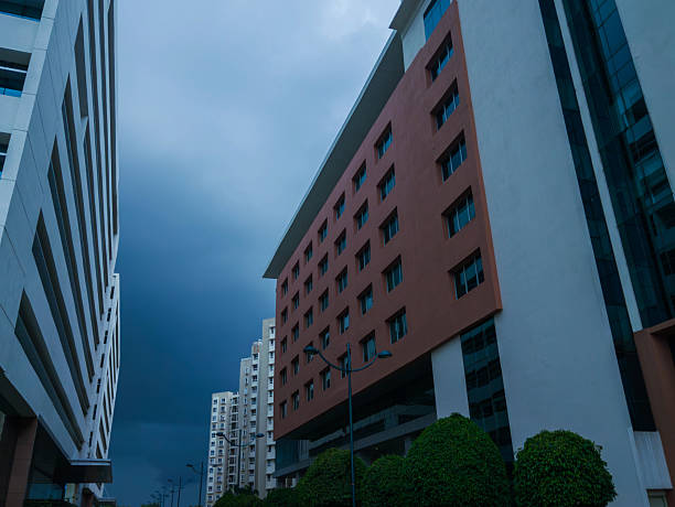 Modern buildings in Bengaluru, India, captured at dusk. Low-angle composition emphasizes architectural lines against a dramatic sky.