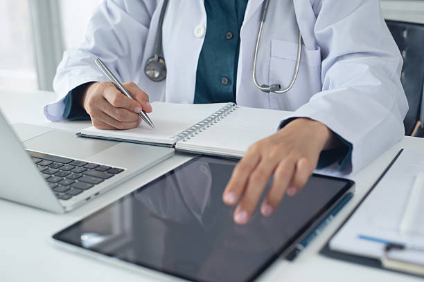 istock Medical student using digital tablet and laptop in research education. Internship doctor searching the information at doctor's office, medical research. Healthcare and medicine, closeup 2226598301