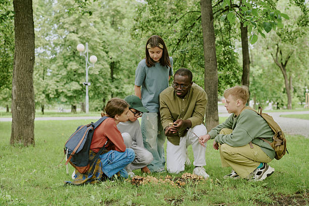 Children explore the river and wildlife in it and looking at the jar what they have collected from the river