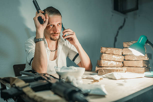 istock Man in Suspenseful Scene with Firearm and Concealed Packages 2226601468