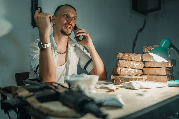 Man in Suspenseful Scene with Packages, Weapon, and Phone Interaction