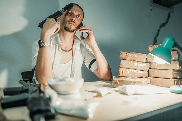 istock Man in Intense Setting Surrounded by Parcels and Armed with a Gun 2226601471