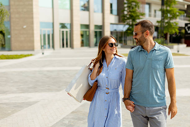 istock Couple enjoying a sunny day in a modern shopping district while sharing laughter and holding hands 2226603699