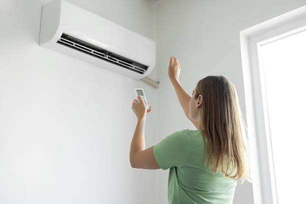 istock Woman turning on air conditioner with remote 2226603864