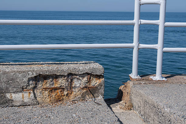 old concrete wall and metal railing by the sea.