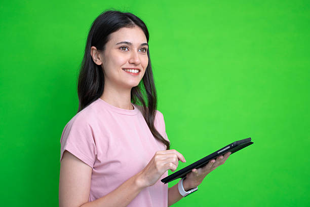 istock A woman is playing digital tablet on green screen. 2226605540