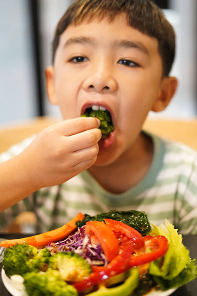 istock Boy enjoy eating vegetable salad on the table 2226608844
