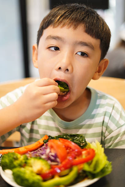 istock Boy enjoy eating vegetable salad on the table 2226608861