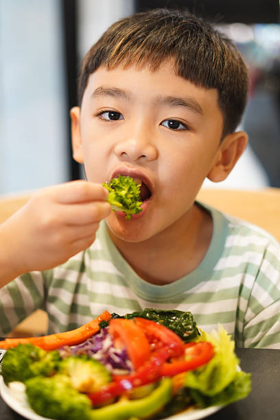 istock Boy enjoy eating vegetable salad on the table 2226608872