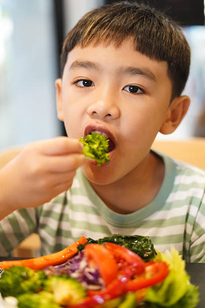 istock Boy enjoy eating vegetable salad on the table 2226608873