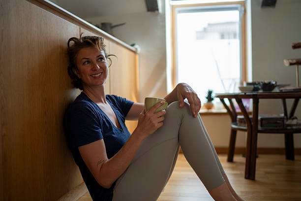 istock Smiling woman relaxing with coffee in modern kitchen 2226609381