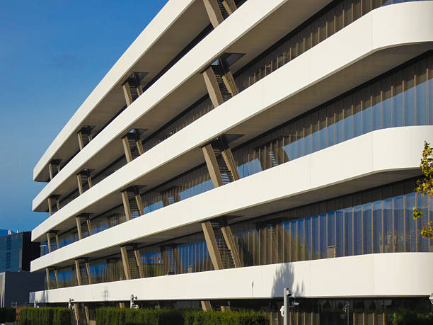 Perspective photo of a recent corporate building with a modern design, many windows, and a white facade. This  enterprise photograph was taken near Geneva, Switzerland.