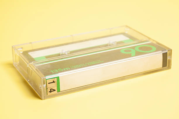 Close up of retro audio cassette tape on yellow background.