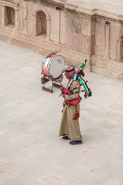 Jerash, Jordan - November 7, 2022: Jordanian bagpipe player in the roman theatre of the archeological site