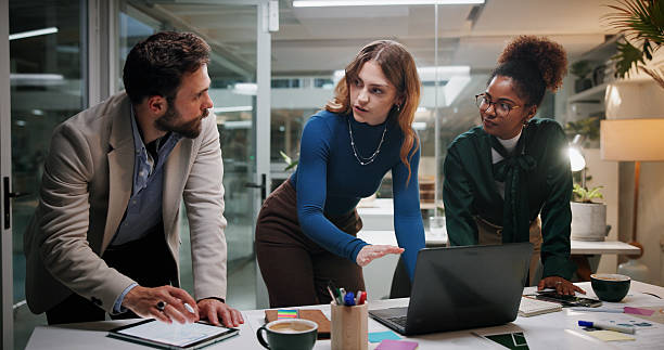 istock Creative, teamwork or planning with laptop in office at night for marketing campaign, design feedback or brainstorming. Graphic designer, people or discussion for brand development, ideas or overtime 2226612815
