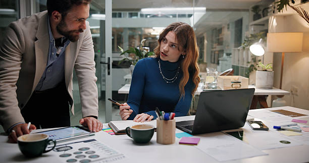 istock Business people, notebook and tablet in office for discussion, project feedback and advice at night. Journalist team, planning and tech in agency for article notes, collaboration and late information 2226612861