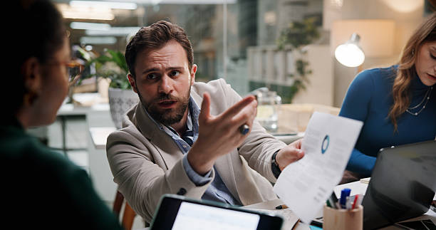 istock Businessman, paperwork and meeting in office for finance, budget information or problem solving at night. Admin staff, document and overtime in agency with profit mistake, briefing or review offer 2226612923