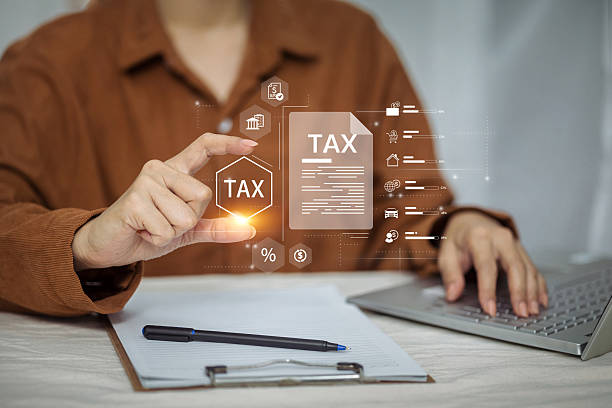 istock A person uses a laptop while interacting with a complex holographic display for managing and analyzing tax data. 2226614342