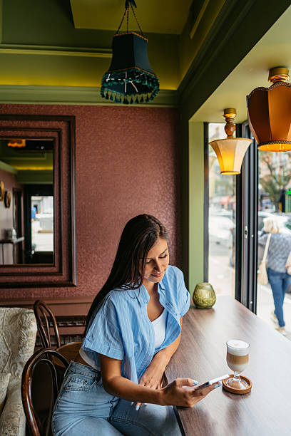 retro toned image of a young woman sitting in a cafe in popular and vibrant Berlin Kreuzberg district, having a coffee.