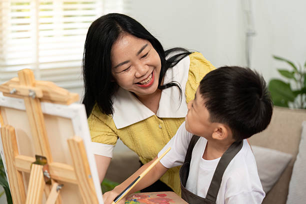 istock Artistic Connection. Mother encouraging son during painting session. 2226615016