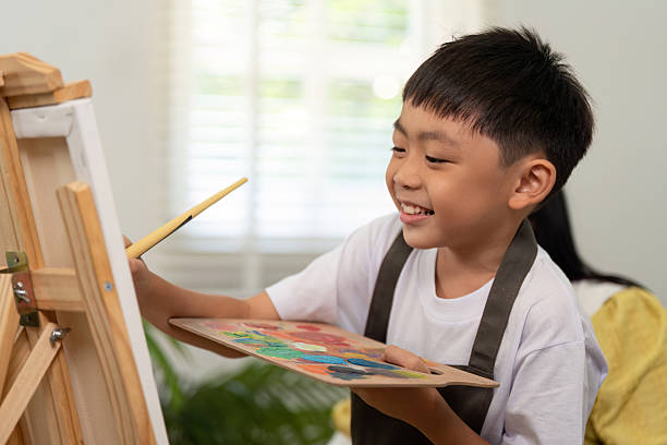 istock Creative Expression. Young boy painting on canvas with joy. 2226615025