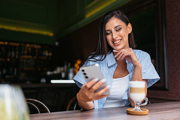 istock Young Woman Drinking Coffee While Using Her Phone In A Coffee Shop 2226615104