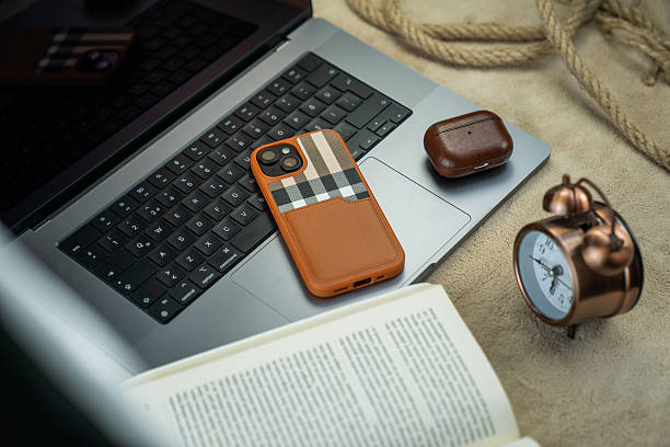 istock Smartphone, Bluetooth Earbuds, and Desk Clock on a Gray Laptop 2226616187