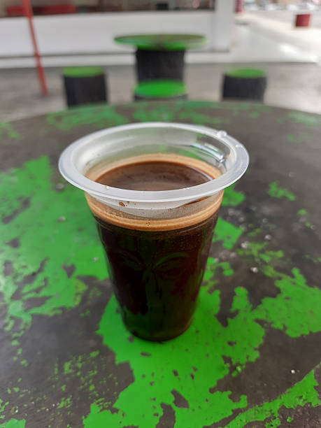 istock Plastic Cup of Black Coffee Resting on a Weathered Green Table Outdoors 2226620976