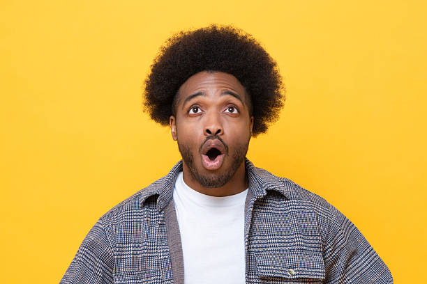 istock Surprised man looking up and reacts with shock on yellow background 2226622865
