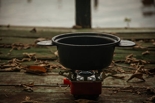 cooking some fried cakes on a portable stove in the open air.