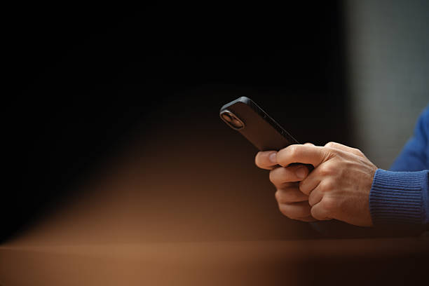 istock Person interacts with smartphone in a dimly lit setting during an evening gathering 2226625641