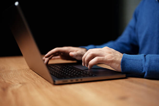 istock Hands typing on laptop at wooden desk in a cozy setting during evening hours with soft lighting 2226625644