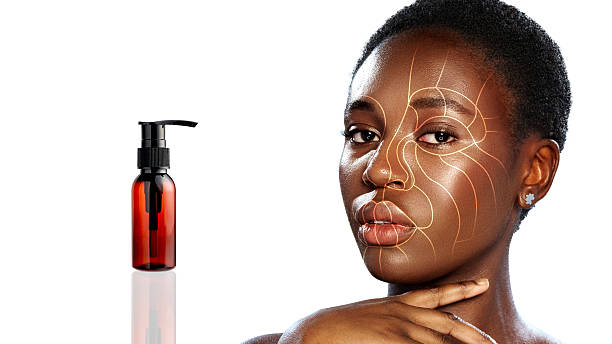 istock Skincare routine featuring a model applying product on her face with serum bottle in studio setting 2226625762