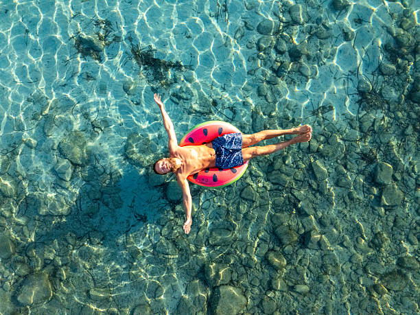 istock Man Relaxing on Float in Clear Blue Water 2226629697
