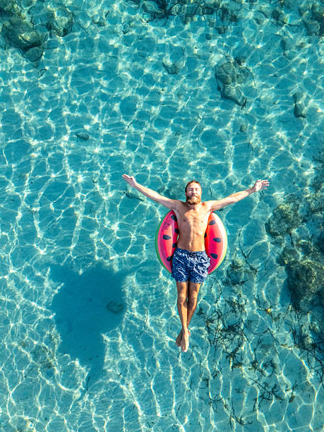 istock Man Relaxing on Float in Clear Blue Water 2226629875